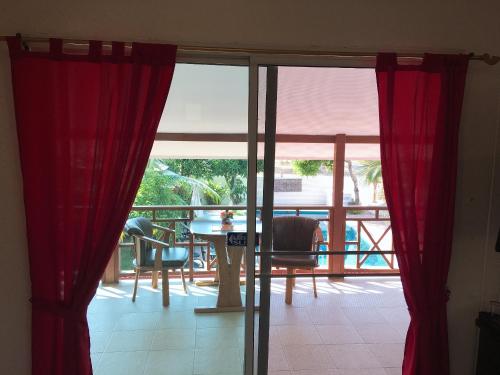 a room with red curtains and a table and chairs at Naraya Homestay in San Pa Tong