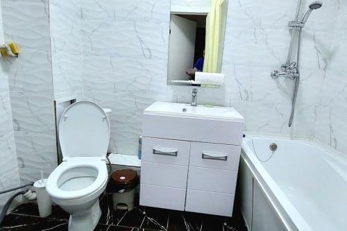 een badkamer met toilet, wastafel en bad bij Аэропорт 10 минут in Astana