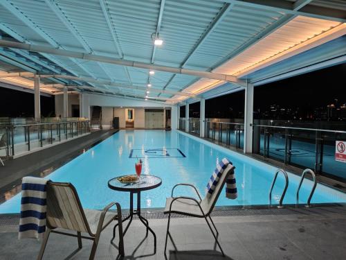 a large swimming pool with a table and chairs at Grand G7 Hotel Pasar baru in Jakarta
