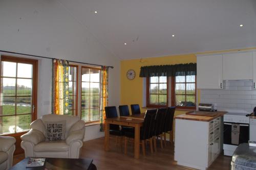 a kitchen and living room with a table and chairs at Good Morning Bed and Breakfast in Härslöv