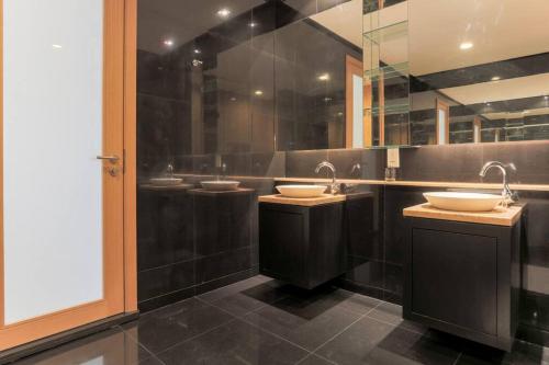 クアラルンプールにあるLarge 3-Bedroom Modern Resort Style KLCC Apartmentの洗面台3つと鏡2つ付きのバスルーム