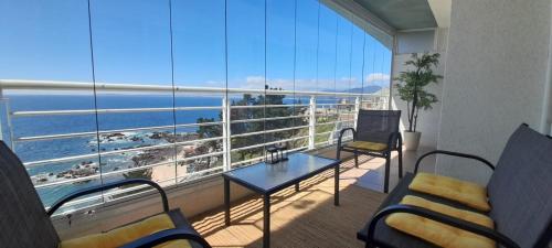 a room with a balcony with a view of the ocean at Maravilloso departamento con vista panorámica. in Concón