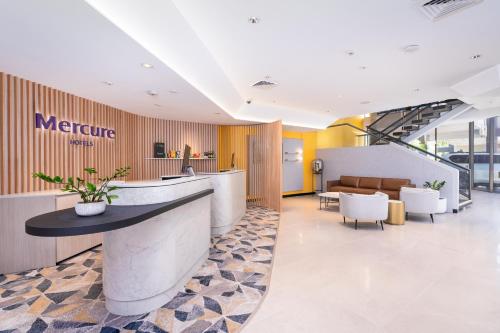 an office lobby with a reception counter and chairs at Mercure Rockhampton in Rockhampton