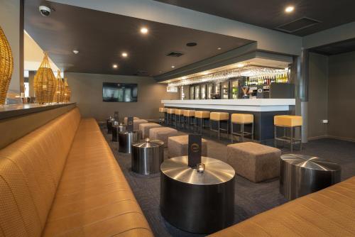 a bar with a row of stools in a restaurant at Mercure Rockhampton in Rockhampton