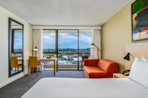a hotel room with a bed and a desk and chair at Mercure Rockhampton in Rockhampton