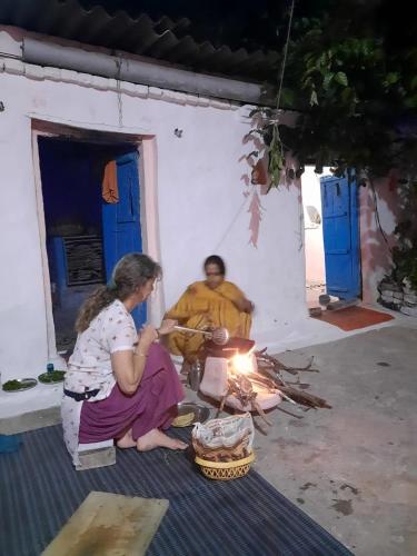 a man and a woman sitting next to a fire at Orchha Best Homestay in Orchha