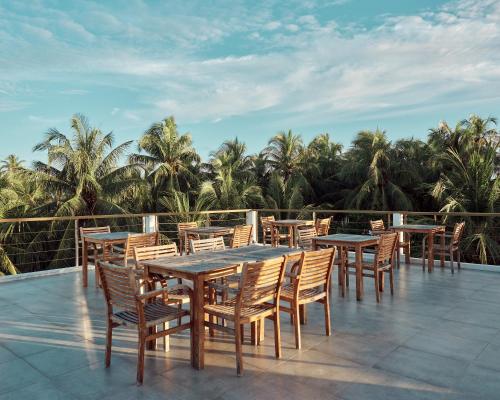 a row of tables and chairs on a patio at Bliss Dhigurah in Dhigurah
