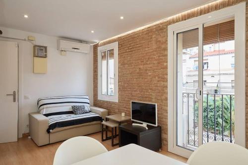 ein Wohnzimmer mit einem Sofa und einem TV in der Unterkunft GuestReady - Cosy Apt in La Barceloneta in Barcelona