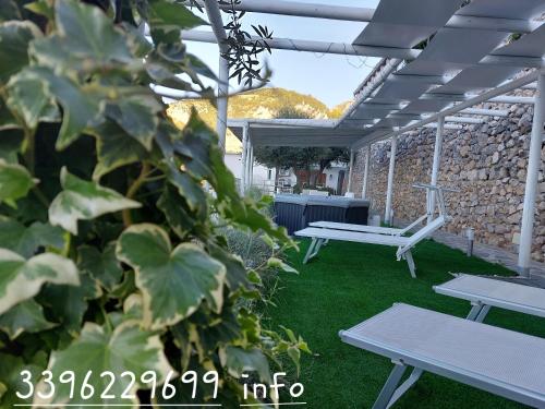 un patio con 2 mesas de picnic y una pared de piedra en Villa Cimea en Furore