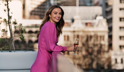 a woman in a pink dress holding a glass of wine at Lancemore Crossley St. Melbourne in Melbourne
