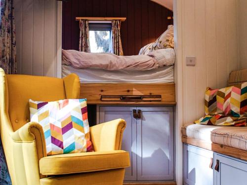 a room with a chair and two bunk beds at Little Willows in Potterne