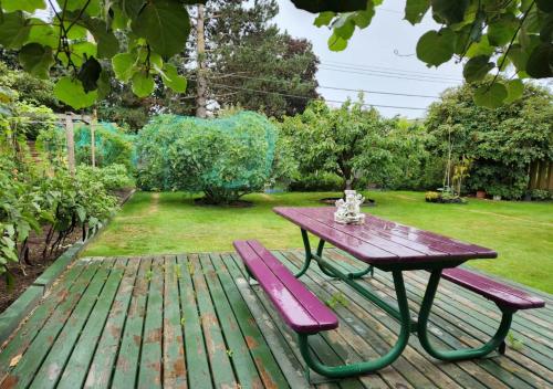 a picnic table and a bench on a wooden deck at private single room in a house in Richmond