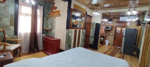 a bedroom with a bed in a room with wooden floors at Apartotel VILLA ALTA TAMARINDO in Tamarindo