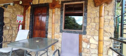 a stone house with a table and a window at Apartotel VILLA ALTA TAMARINDO in Tamarindo
