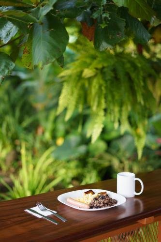 a plate of food and a cup of coffee on a table at Cabañas del Rio in Fortuna