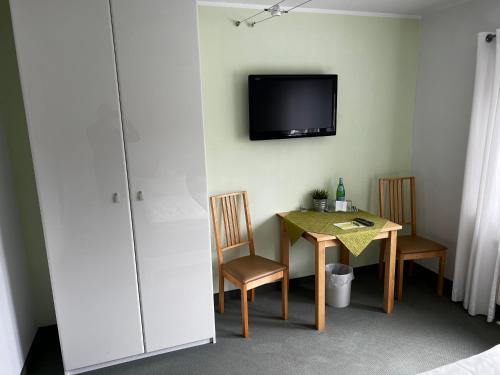 a room with a table and a television on the wall at Gästehaus Lena in Mudau