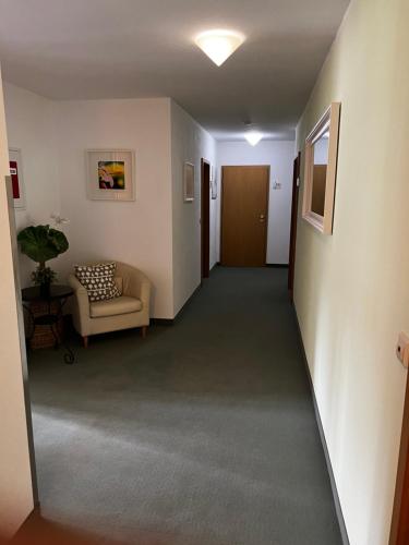 a hallway with a couch and a chair in a room at Gästehaus Lena in Mudau