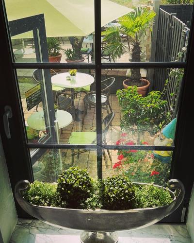 una ventana con vistas a un jardín con mesa y sillas en Gästehaus Lena, en Mudau