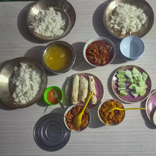 a table with bowls of food with rice and other ingredients at 3 Sisters' Homestay in Ravangla