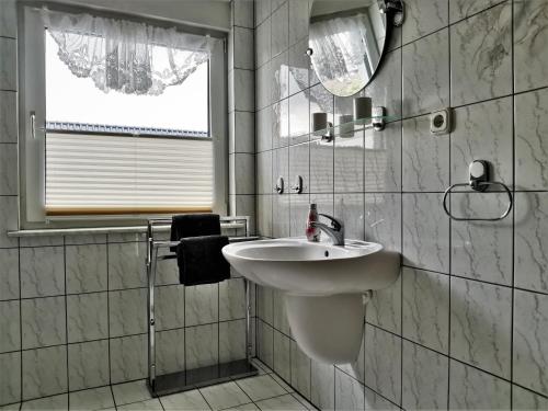 a white bathroom with a sink and a mirror at Ferienhaus Frank in Potzlow