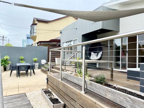 a house with a deck with a dining table at Botanic Beach in Warrnambool