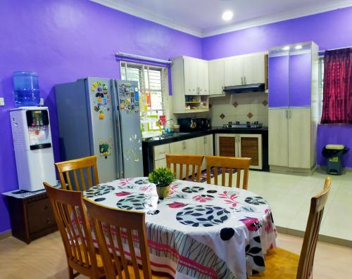 uma cozinha com uma mesa e um frigorífico em Villa Auliyya - MslimOnly em Kampong Sungai Leman