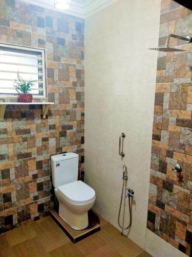 a bathroom with a toilet and a shower at Villa Auliyya - MusleemHomestay in Kampong Sungai Leman