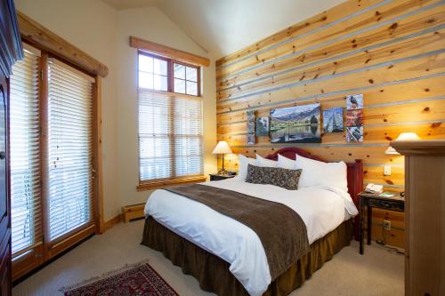 a bedroom with a bed and wooden walls and windows at 3 Bedroom Condo - The Lodges at Deer Valley condo in Park City