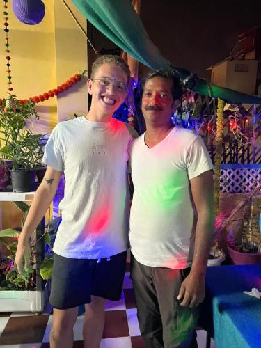 two men standing next to each other with their paint on their shirts at Black Pepper Home Stay in Udaipur