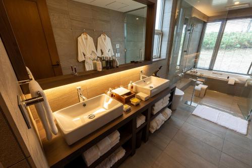 a bathroom with two sinks and a large mirror at Biei Villa Rubeshibe Hill in Biei