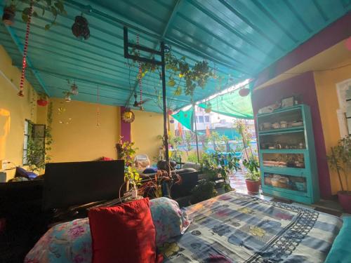 Black Pepper Home Stay في أودايبور: غرفة مع سرير وطاولة مع لاب توب
