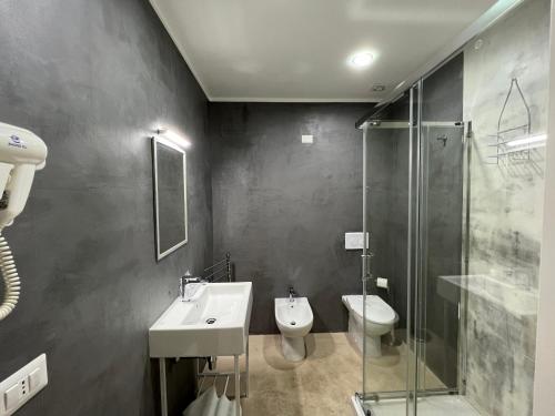a bathroom with a sink and a toilet and a shower at La Piazza BeB in Tropea