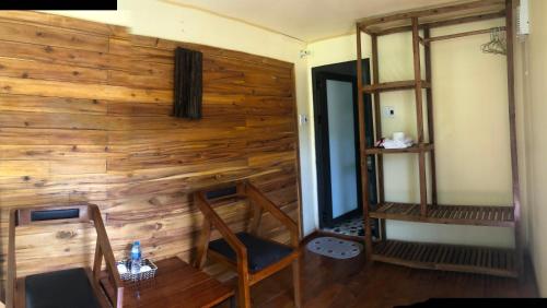 a room with a wooden wall with a chair and a shelf at Cat Ba Love House in Cat Ba
