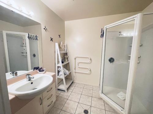 a bathroom with a sink and a shower at Oceanside Apartment in Mount Maunganui