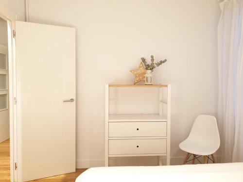a bedroom with a white dresser and a chair at GREAT LOCATION & 130m2! Guggenheim & Parking in Bilbao