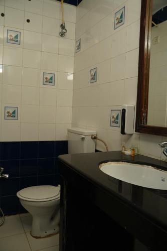 a bathroom with a toilet and a sink at Alagoa Resort in Betalbatim