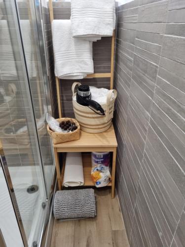 uma pequena casa de banho com chuveiro e uma prateleira com toalhas em Happy Home em Catânia
