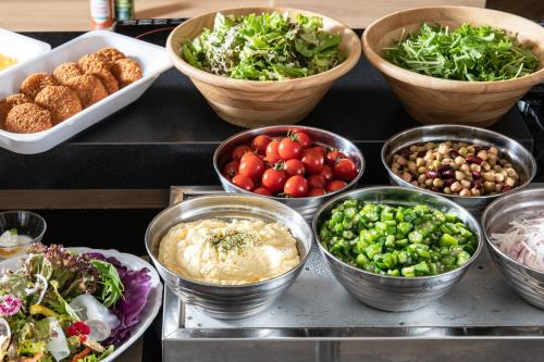 a buffet with bowls of different types of food at Hotel Vista Fukuoka Nakasu-Kawabata in Fukuoka