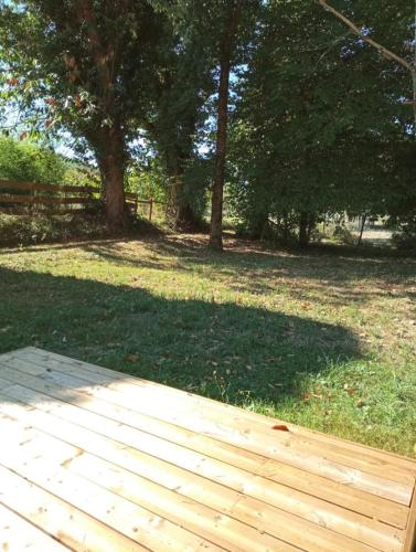 une passerelle en bois dans un parc planté d'arbres et d'herbe dans l'établissement Chambre au calme entourée par la nature., à Saint-Léon-sur-Vézère