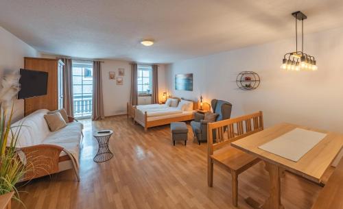 een woonkamer met een bank en een tafel bij Hotel Wirt z´ Engelsberg in Engelsberg
