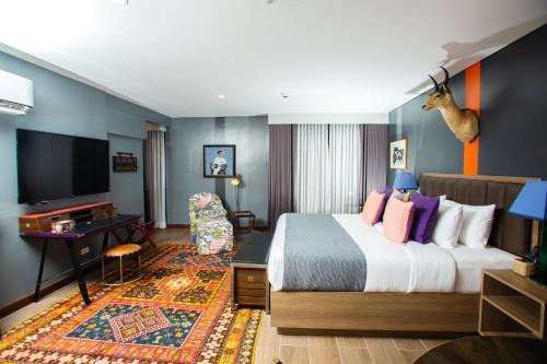 a hotel room with a bed and a desk at UNWND Flats in Manila