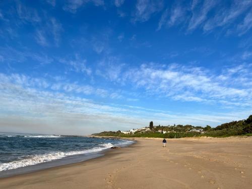 une personne se promenant sur une plage près de l'océan dans l'établissement Gracelands Beach Lodge, à Ramsgate