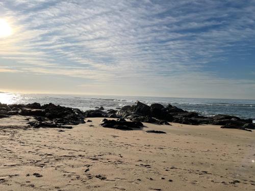 a beach with rocks in the sand and the ocean at Gracelands Beach Lodge in Ramsgate