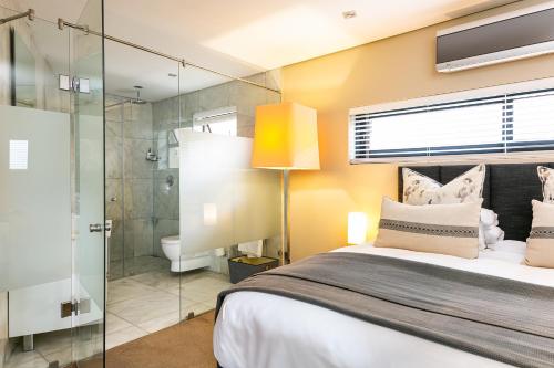 a bedroom with a bed and a glass shower at Lions Eye Luxury Apartments in Cape Town