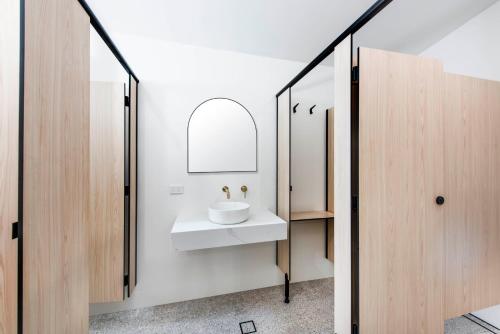 a bathroom with a white sink and a mirror at The Paragon Hotel in Mudgee