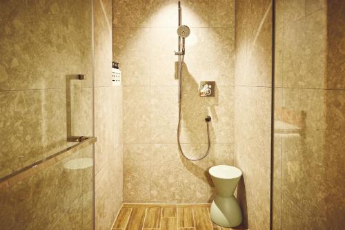 a bathroom with a shower with a toilet at Hotel Indigo Inuyama Urakuen Garden, an IHG Hotel in Inuyama