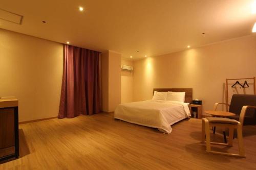 1 dormitorio con cama y cortina roja en Hotel Violet, en Goyang