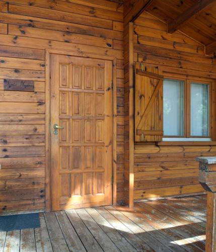 an entrance to a wooden cabin with a wooden door at El Llano de los Conejos Serranía de Cuenca in Cañamares