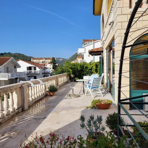 a balcony with a table and chairs on a building at Studio apartman in Meljine