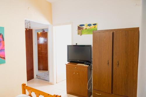 a living room with a television and a cabinet at Arriba Apartments in Afissos